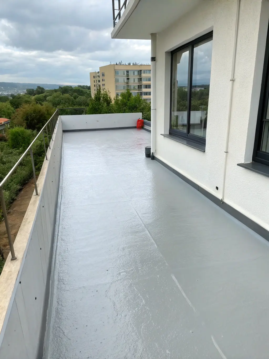 A newly constructed home with a focus on the balcony, showcasing a recently applied, seamless waterproofing membrane. The image should convey quality and attention to detail.